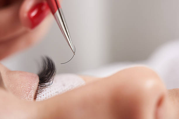 close-up shot of a woman's eye while a professional eyelash tech adds more eyelash hair extension