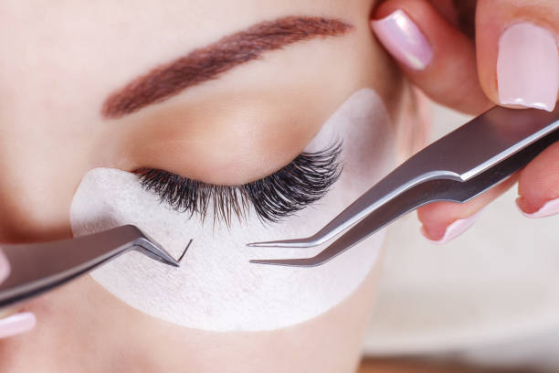 close-up shot of a woman's eye during a lash extension as the lash tech adds more lashes
